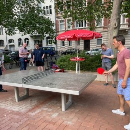 Zwei Personen spielen Tischtennis an einer Outdoor-Platte